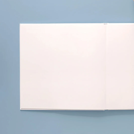 Open layflat photo book with blank pages on a blue background