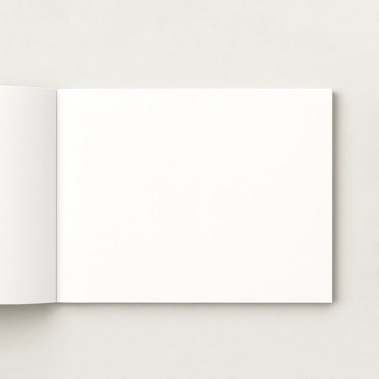 Open softcover photo book with blank pages on a light gray background