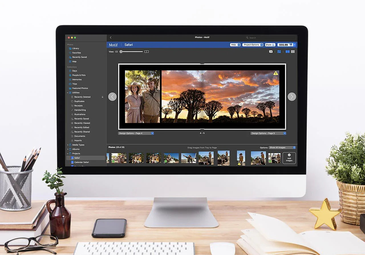 Desktop computer displaying the safari photo book editor with a sunset landscape spread and project tools visible in the top toolbar.