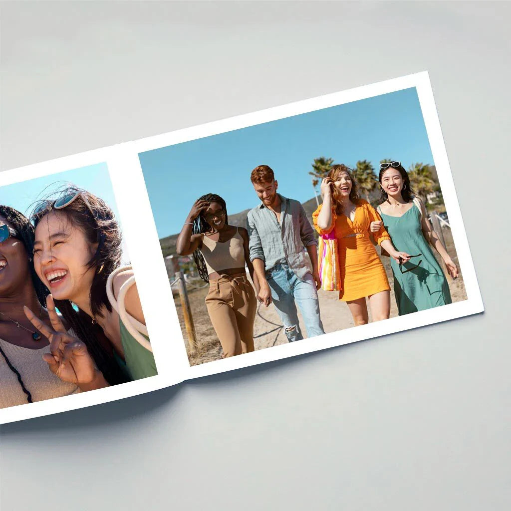 Open photo book displaying friends smiling and walking outdoors on a sunny day.